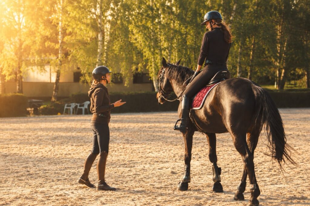Trenerka rozmawia z jeźdźcem przez interkom eQuestConnect na placu