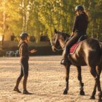 Trenerka rozmawia z jeźdźcem przez interkom eQuestConnect na placu